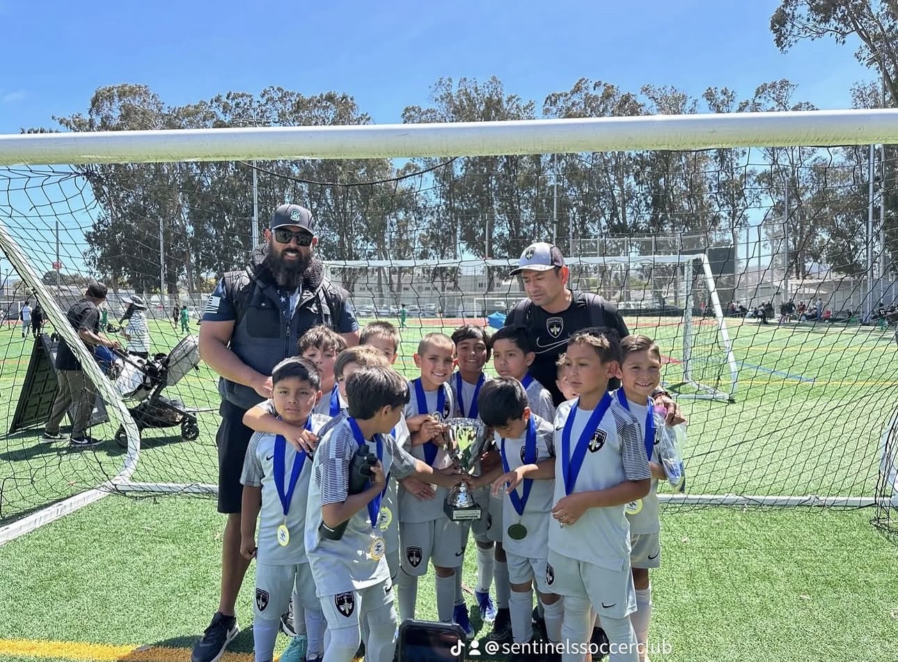 Sentinels young boys team holding championship cup at goal